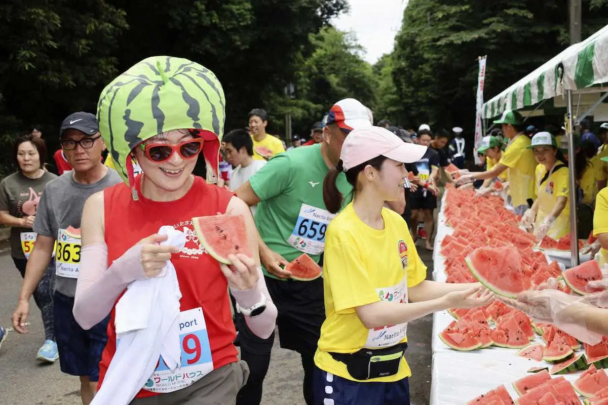 千葉県富里市で開かれたマラソン大会「富里スイカロードレース」で、スイカを手に取るランナーたち