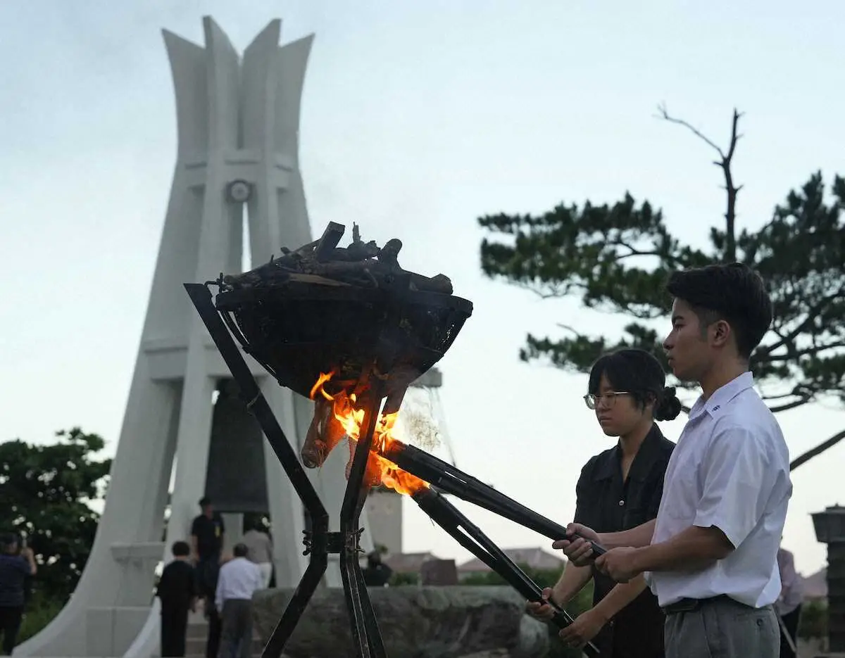 沖縄全戦没者追悼式の前夜祭で「鎮魂の火」をともす遺族代表