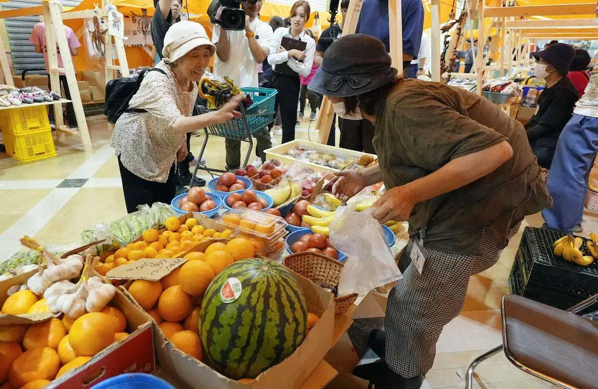 輪島朝市で、野菜や果物を買い求める客