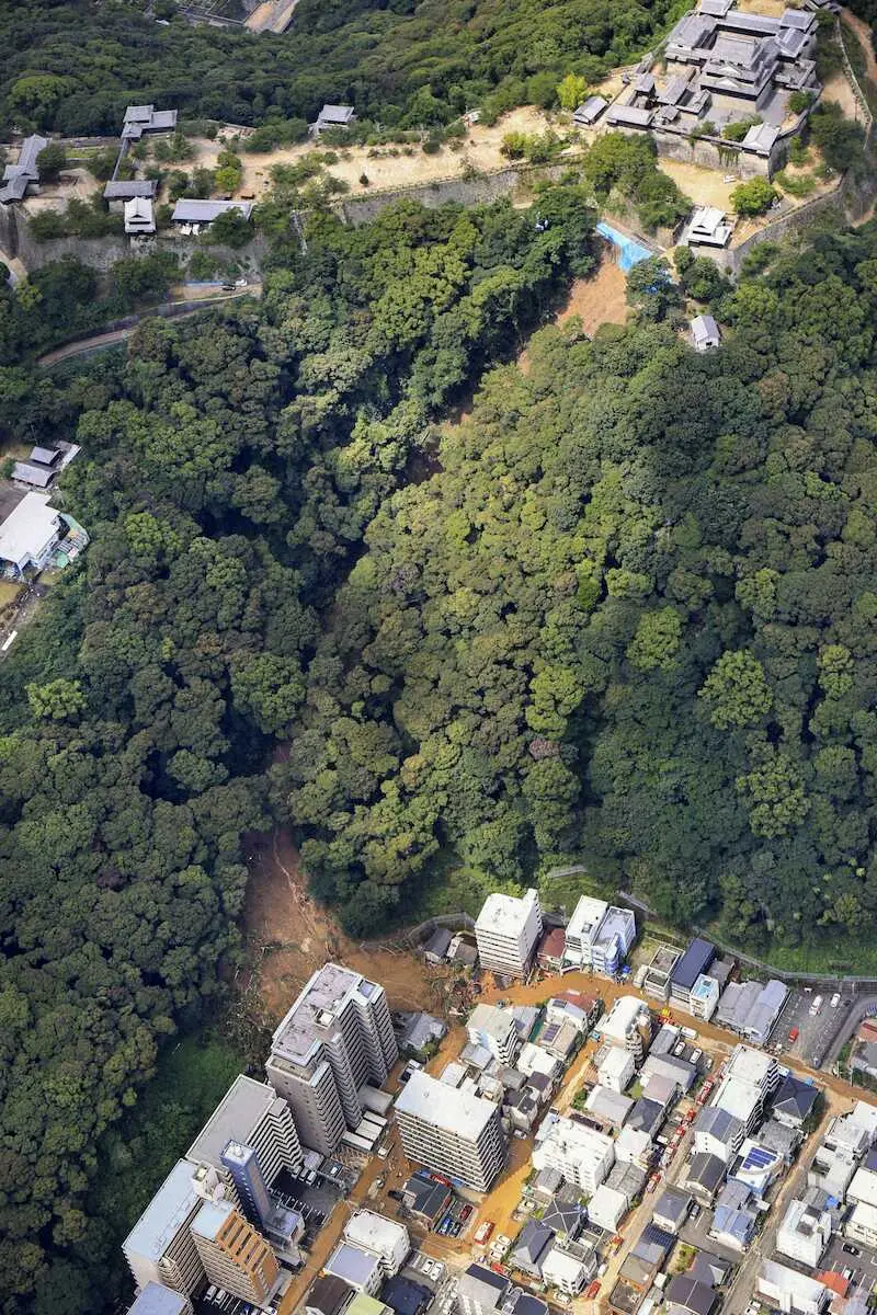 松山城（右上）付近の山の斜面が崩れ、土砂が住宅地に流れ込んだ現場（共同通信社ヘリから）