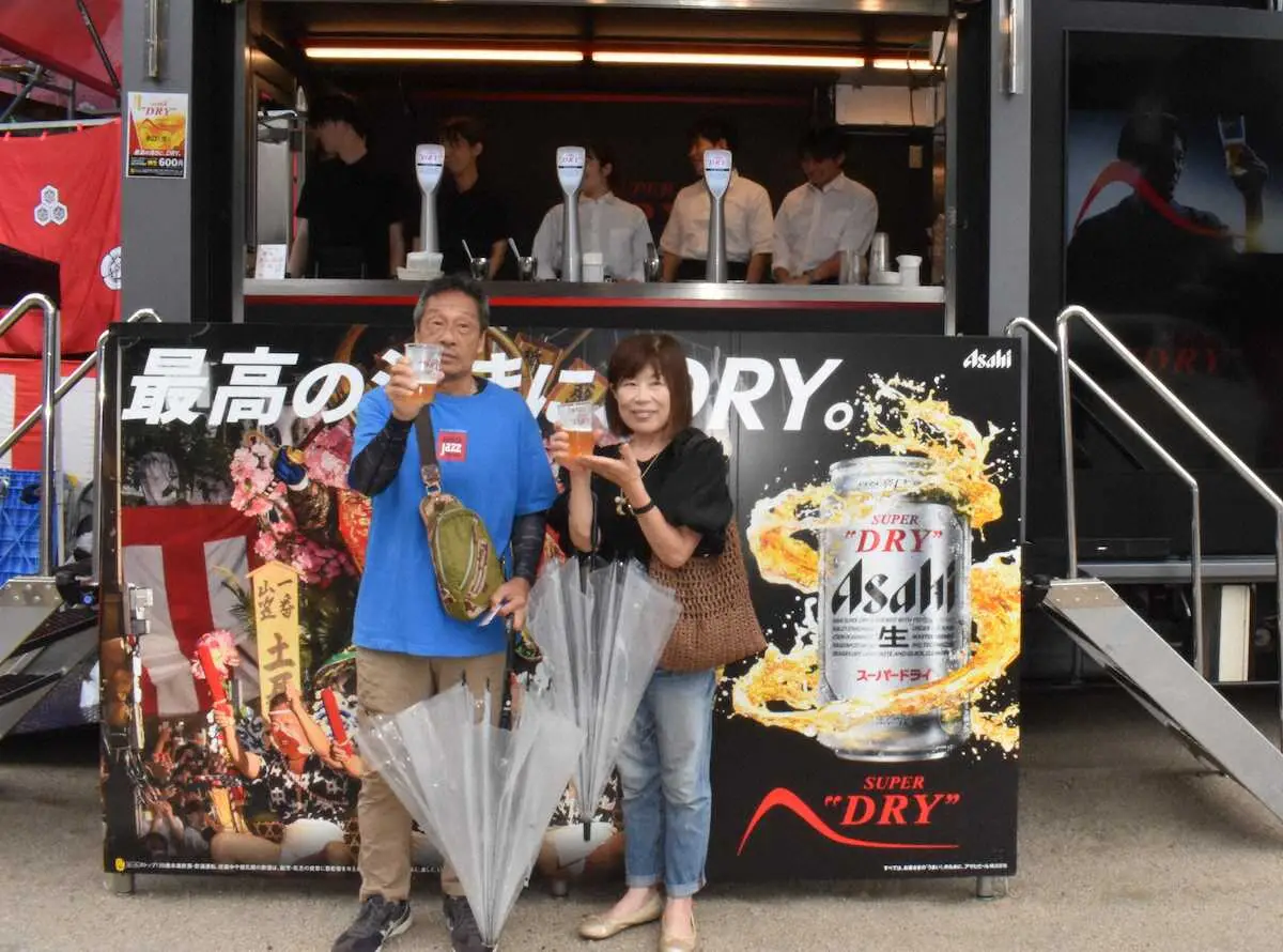 櫛田神社の清道に設置されたアサヒスーパードライのブランドカーで博多工場直送のできたてビールを手に笑顔の夫婦