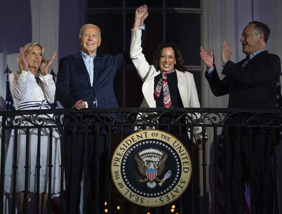 4日、米ホワイトハウスのバルコニーで、ハリス副大統領（中央右）の手を取るバイデン大統領（AP）