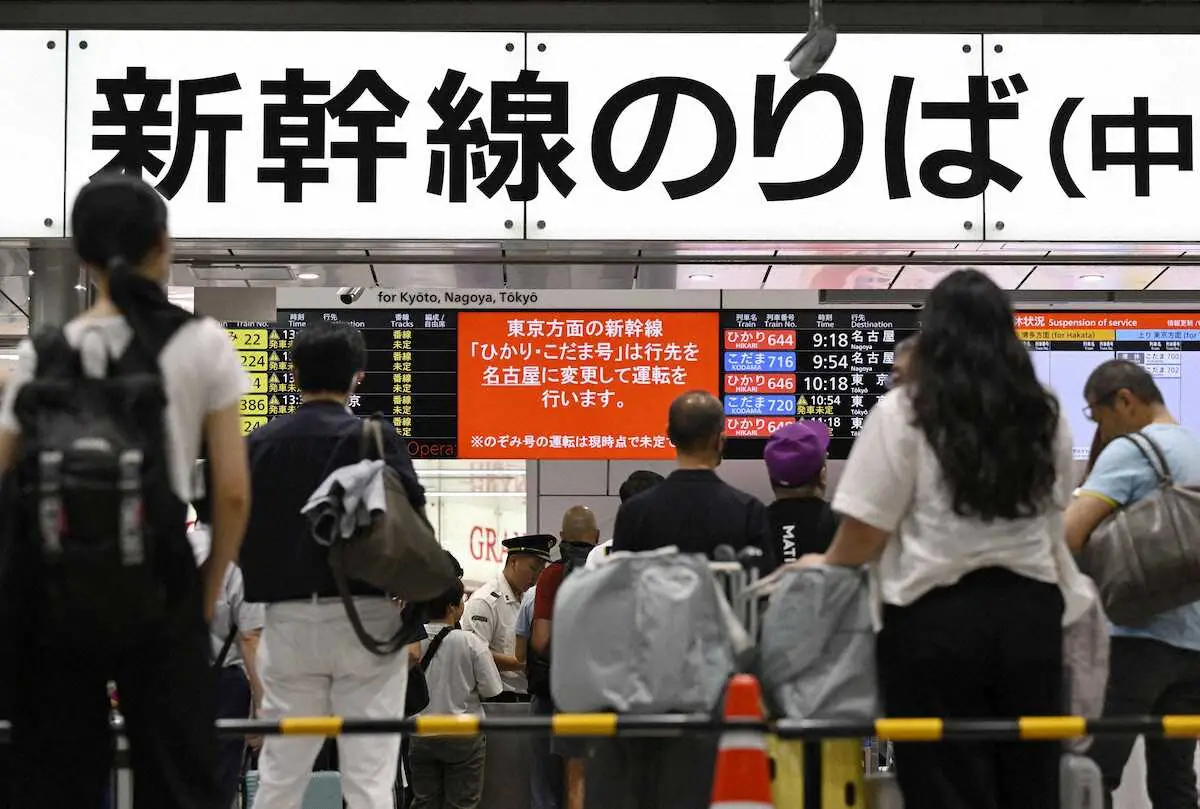 東海道新幹線のダイヤが乱れ、JR新大阪駅で掲示板を見る利用客ら＝22日午前