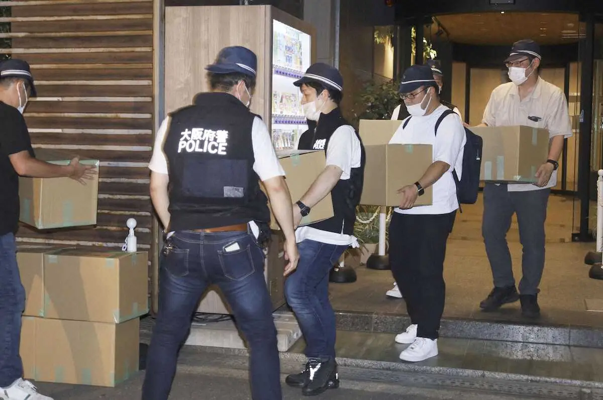 家宅捜索し、段ボール箱を運び出す大阪府警の捜査員ら＝23日午後8時41分、大阪市西区