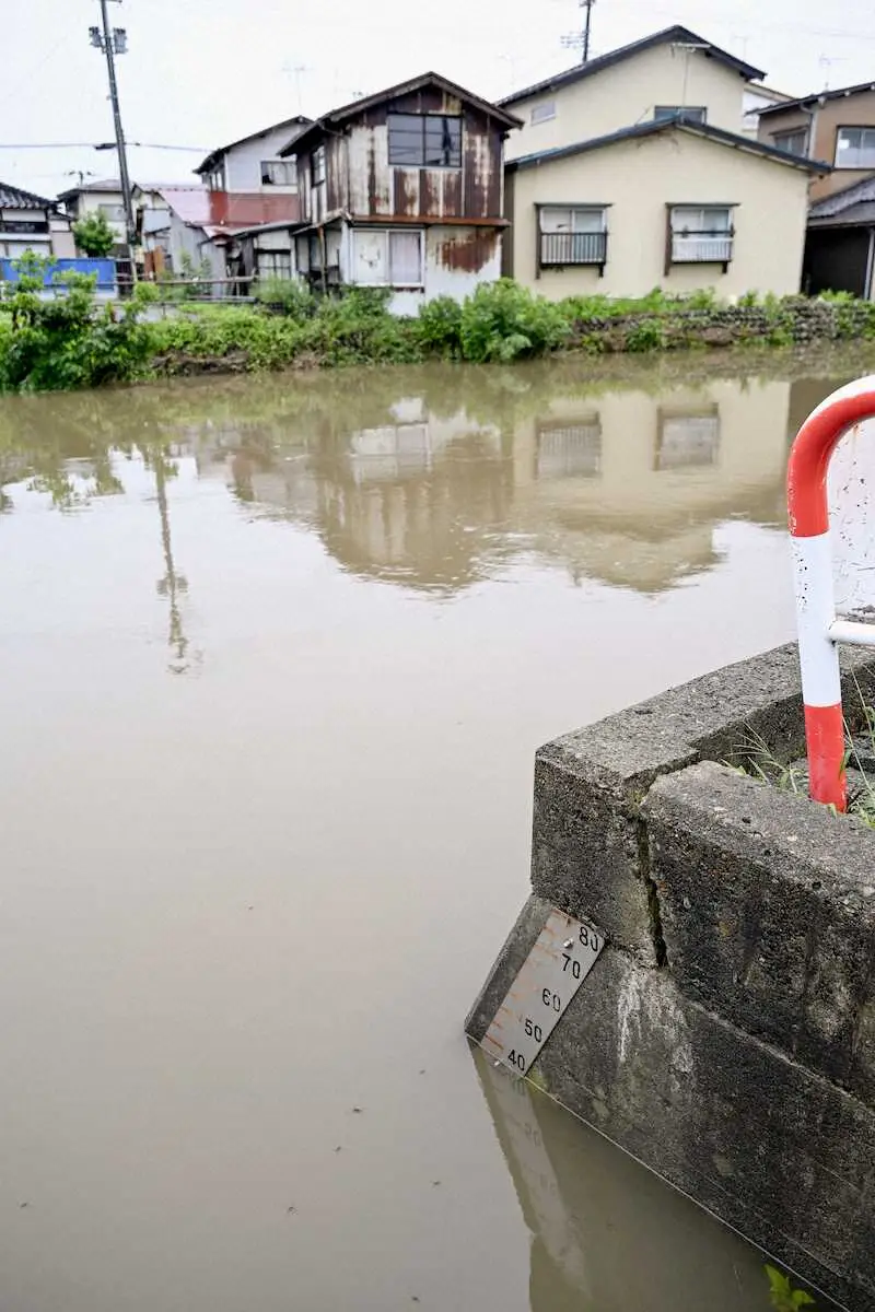 大雨の影響で増水した山形県鶴岡市の内川