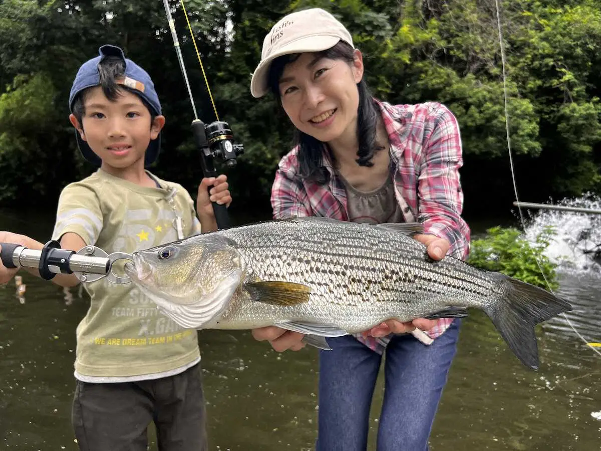 滉介さんが釣った58センチのストライパーと、それを喜ぶ恵子さん。こういうツーショットは珍しくそして素敵！