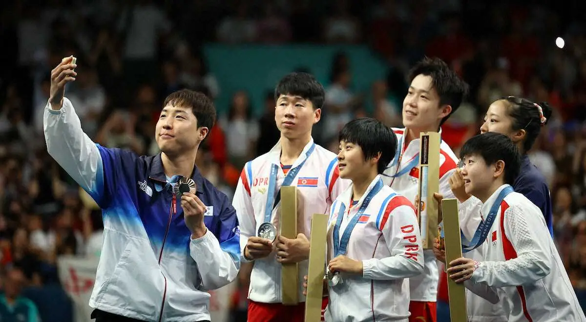 韓国選手らと記念撮影する北朝鮮選手（ロイター）