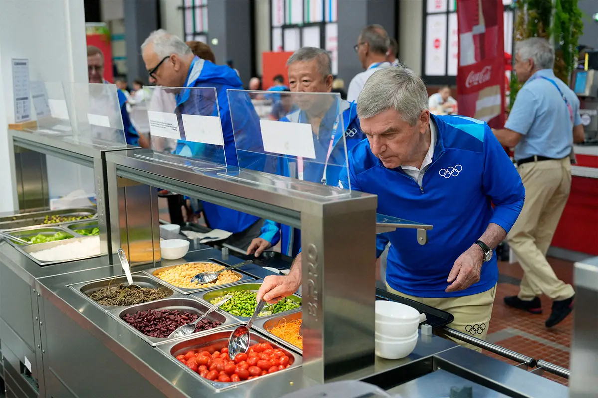 パリ五輪選手村の食堂で料理を取るIOCのバッハ会長（ロイター）