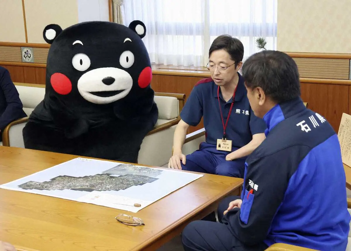 石川県庁を訪れ、馳浩知事（手前）と面会する「くまモン」。奥は熊本県の木村敬知事