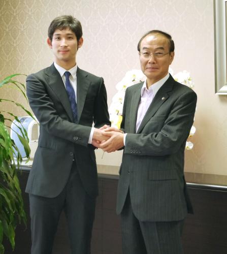 大久保博市長（右）と握手を交わすロンドン五輪フェンシング日本代表の三宅諒