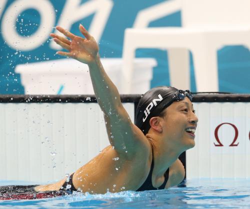 ＜競泳女子１００メートル背泳ぎ準決勝＞全体３位で決勝に進出し、声援に手を挙げて応える寺川