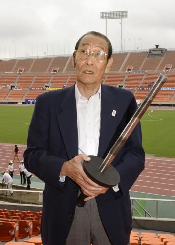 １９６４年の東京五輪で聖火台に点火したトーチを手にする坂井義則氏＝２０１３年９月、国立競技場