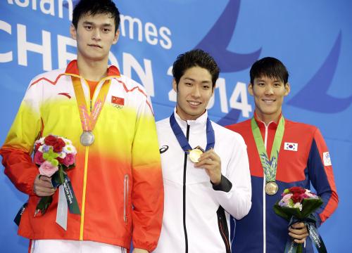 アジア大会競泳男子２００メートル自由形を日本新記録で制し、金メダルを手にする萩野公介。左は２位の孫楊、右は３位の朴泰桓