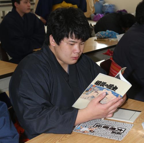 真剣な表情で相撲の歴史の教科書を読む宇良