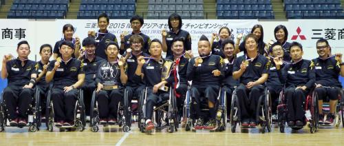 優勝を決めメダルを手に記念写真に納まる車いすラグビー日本代表の選手ら