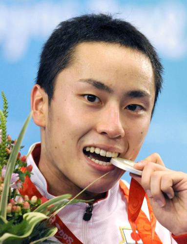 ２００８年北京五輪のフェンシング男子フルーレ個人で獲得した銀メダルをかじる太田雄貴