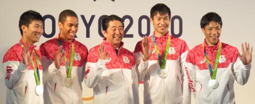 安倍首相（中央）と笑顔で写真に納まる男子４００メートルリレーのメンバー（左から桐生祥秀、ケンブリッジ飛鳥、一人おいて飯塚翔太、山県亮太）