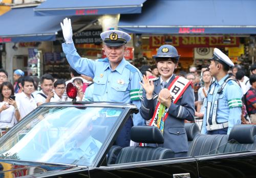 ＜１日警察署長＞福原愛（右）はリオ五輪のメダルを手に櫻木新宿署長と共に新宿駅前をパレード