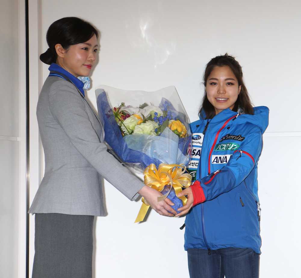 帰国後、航空会社職員から花束贈呈を受け笑顔の高梨沙羅