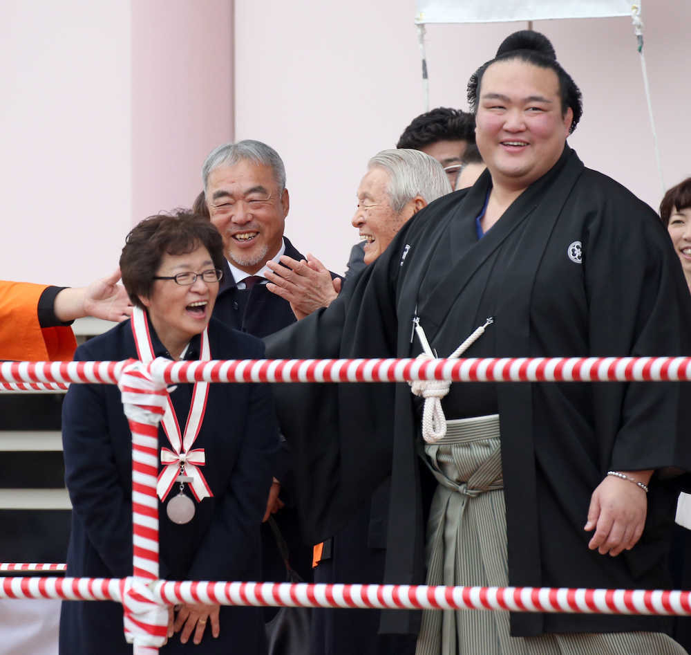 母・萩原裕美子さんに牛久市民栄誉賞のメダルを逆に掛けてあげ笑顔の稀勢の里。中央は父・貞彦さん