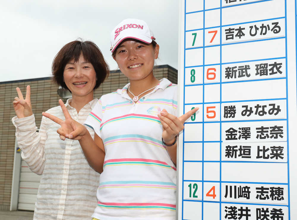 女子プロテスト最終日　５アンダーで合格の勝（右）は、母・久美さんと一緒にボードを指さす