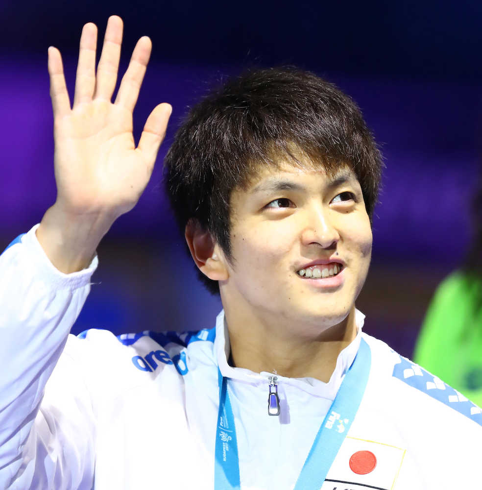 男子５０メートル背泳ぎで銀メダルを獲得し声援に応える古賀