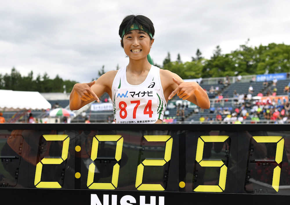 全国高校総体・陸上女子８００メートルで高校新記録となる２分２秒５７で優勝し、タイムを示すボードを前にポーズをとる京都文教・塩見