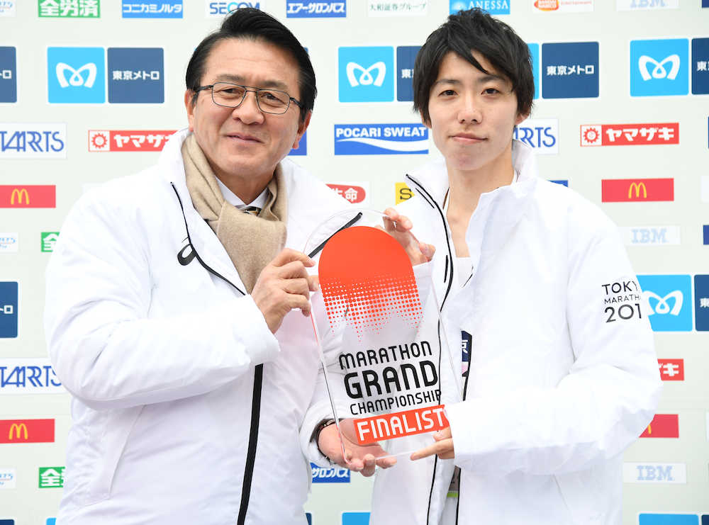 表彰で日本陸上競技連盟強化委員会マラソン強化戦略プロジェクトリーダーの瀬古氏（左）から盾を贈られたマラソン男子２位でゴールした設楽悠（代表撮影）