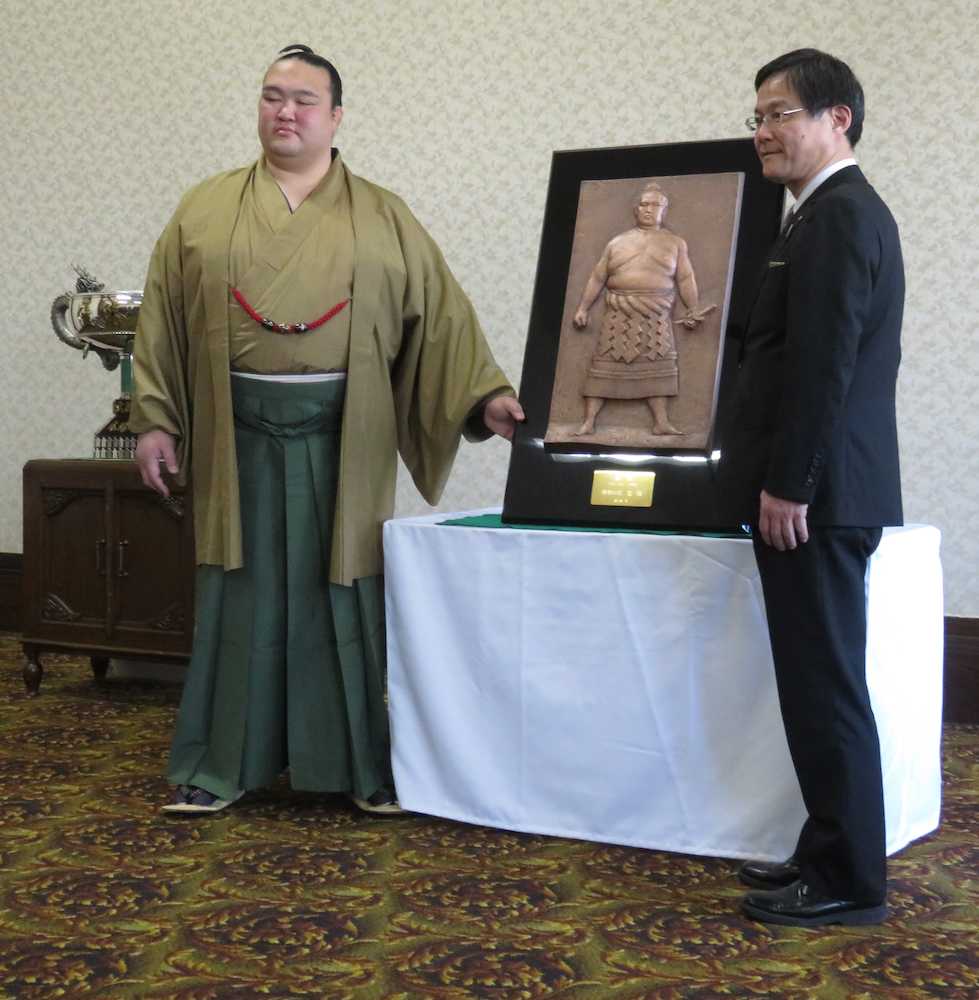 大阪市北区の造幣局で、昨年春場所を制し理事長杯レプリカのレリーフを贈呈される稀勢の里（左）。右は造幣局の百嶋理事長