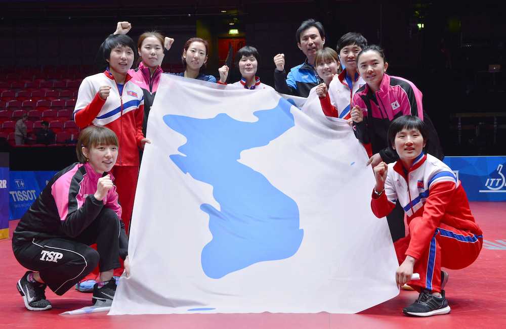 卓球世界選手権団体戦を終え、統一旗を囲みポーズをとる女子の南北合同チーム「コリア」