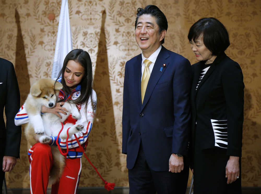 秋田犬の「マサル」を抱くザギトワと、安倍晋三首相、昭恵夫人