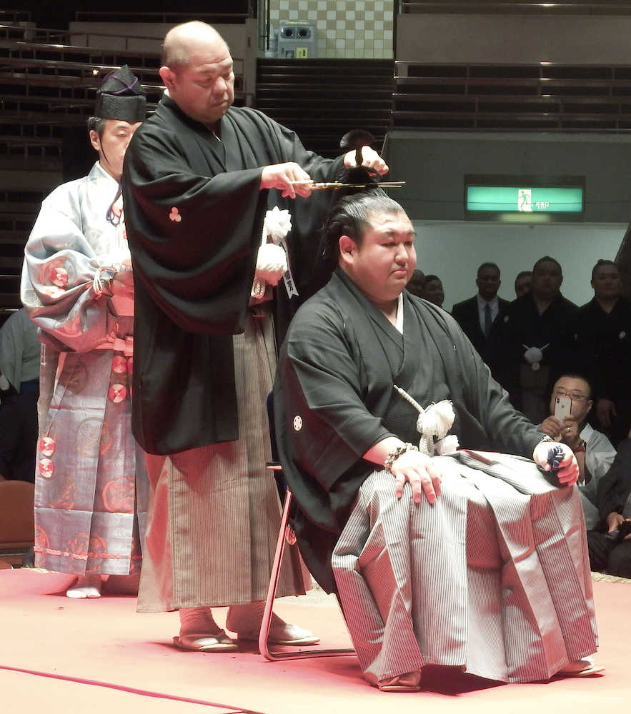大相撲夏場所前に現役を引退した元幕内大岩戸（右）の断髪式で、はさみを入れる師匠の八角親方