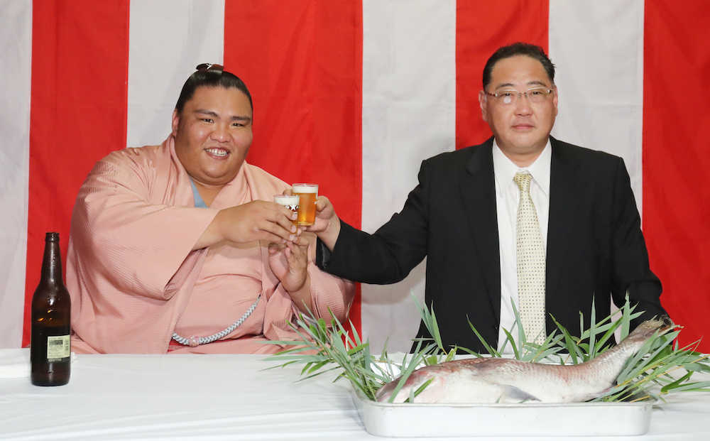 初優勝を飾り、出羽海親方（右）とビールで乾杯する御嶽海（撮影・椎名　航）