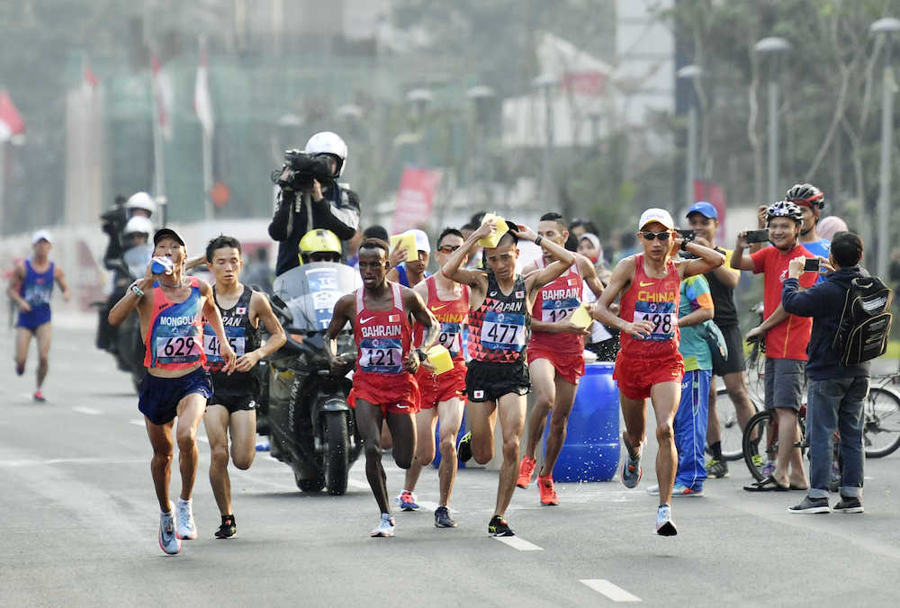 　男子マラソン　レース中盤、スポンジで頭に水をかけながら力走する園田隼（４７７）。左から２人目は井上大仁＝ジャカルタ（共同）