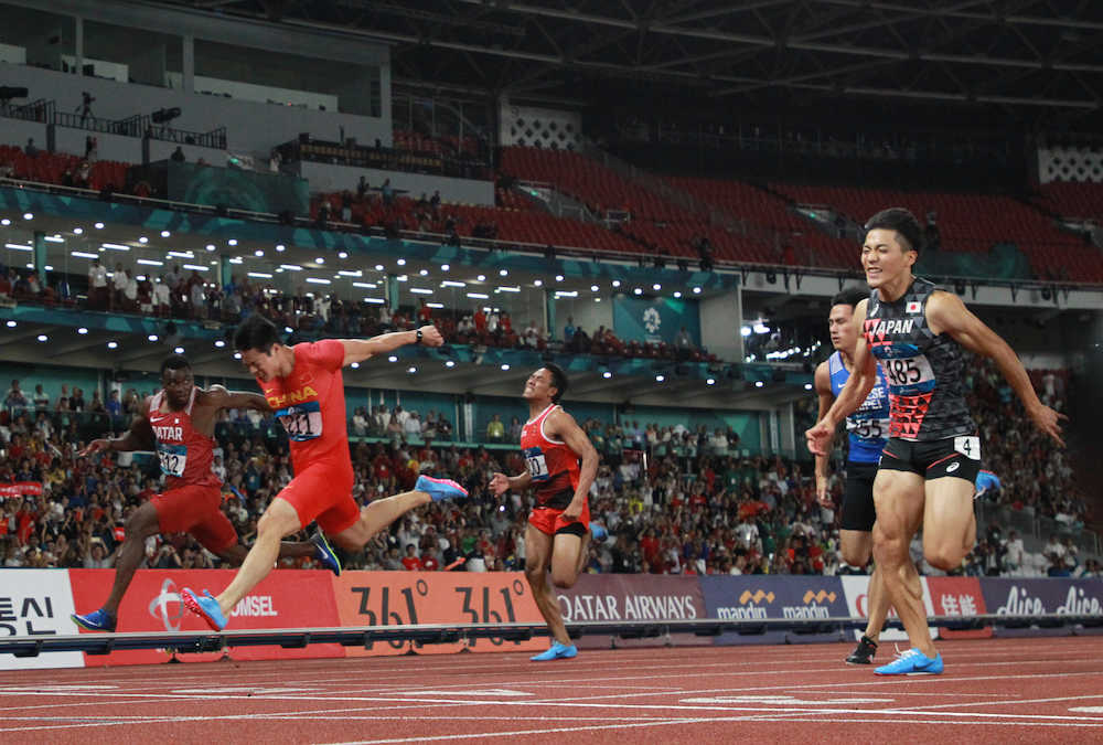 ＜アジア大会陸上＞男子１００メートル決勝、ゴールになだれ込む山県亮太（右）と蘇炳添（左から２人目）（撮影・小海途　良幹）