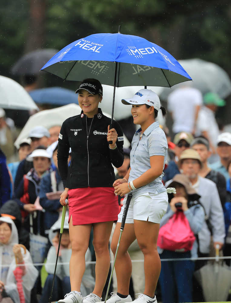 日本女子オープン第３日　雨の中、傘をささずに打順を待つ畑岡（右）は柳簫然の傘に入れてもらい談笑する（撮影・沢田　明徳）
