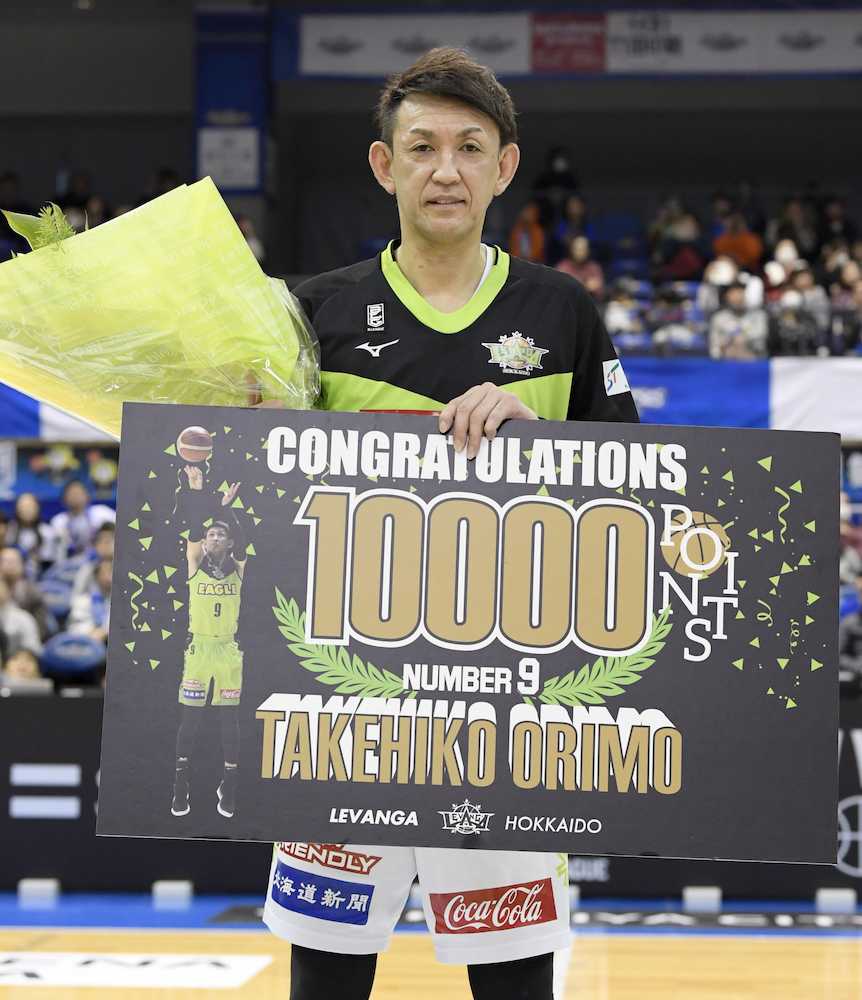 バスケットボール男子Ｂリーグ１部の三河戦で通算１万得点を達成し、記念ボードを手にする北海道の折茂