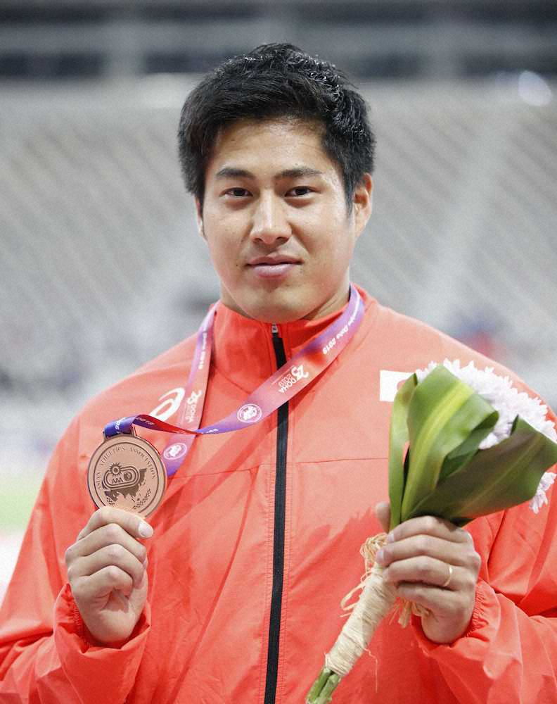 男子やり投げで銅メダルを獲得し、表彰式でポーズをとる新井涼平