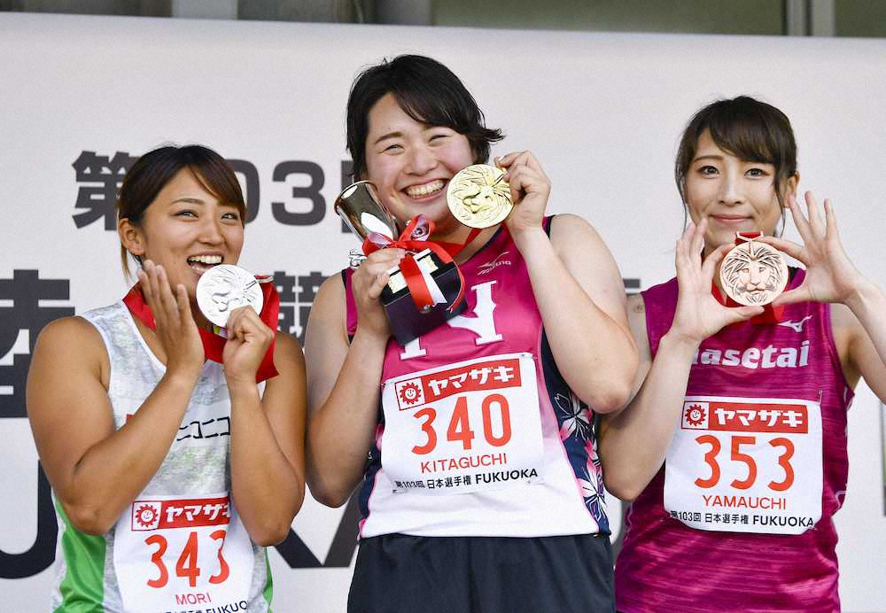 女子やり投げで優勝し、メダルを手に笑顔を見せる北口榛花。左は2位の森友佳、右は3位の山内愛（共同）