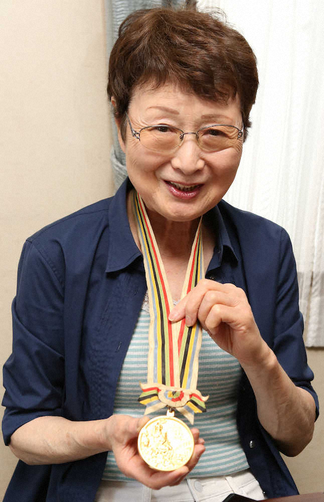 1964年バレーボール女子代表の田村洋子さんは東京五輪の金メダルを首にかける（撮影・荻原　浩人）