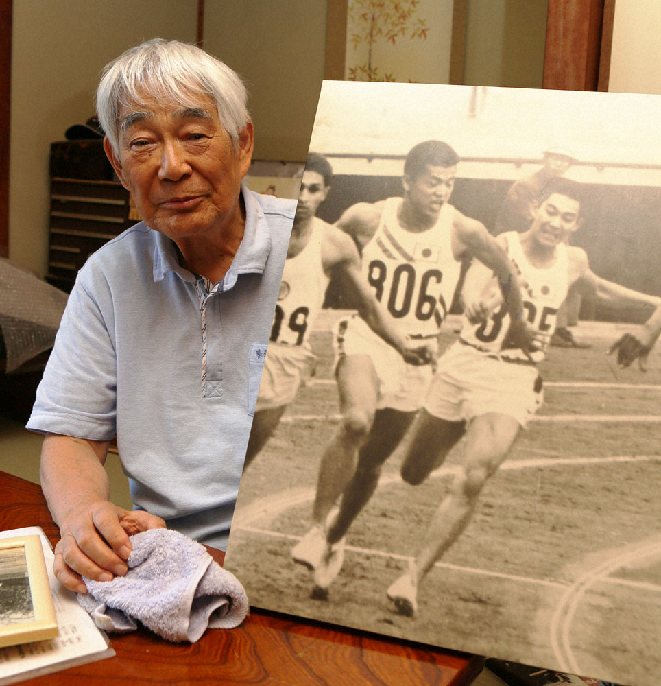 64年東京五輪、男子400メートルリレー出場時の写真を持つ浅井さん（撮影・亀井　直樹）