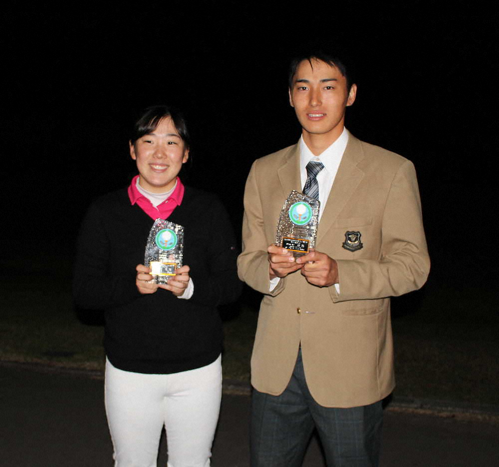 九州高校ゴルフ新人戦で優勝した石塚（右）と岩切は優勝カップを手に笑顔