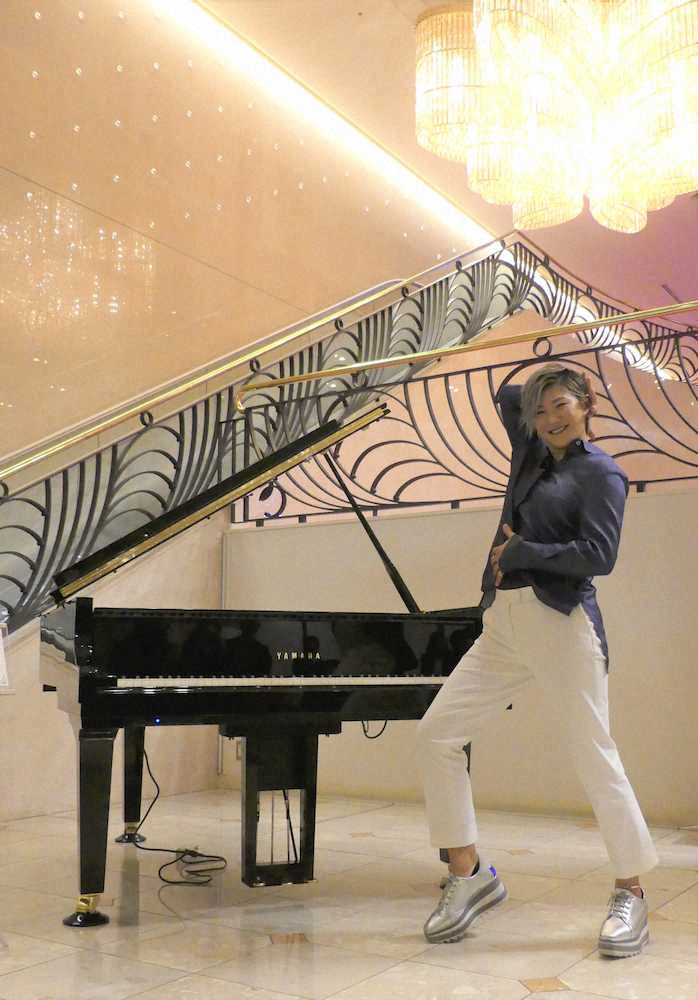 寄贈したグランドピアノの前でポーズをとる成田美寿々