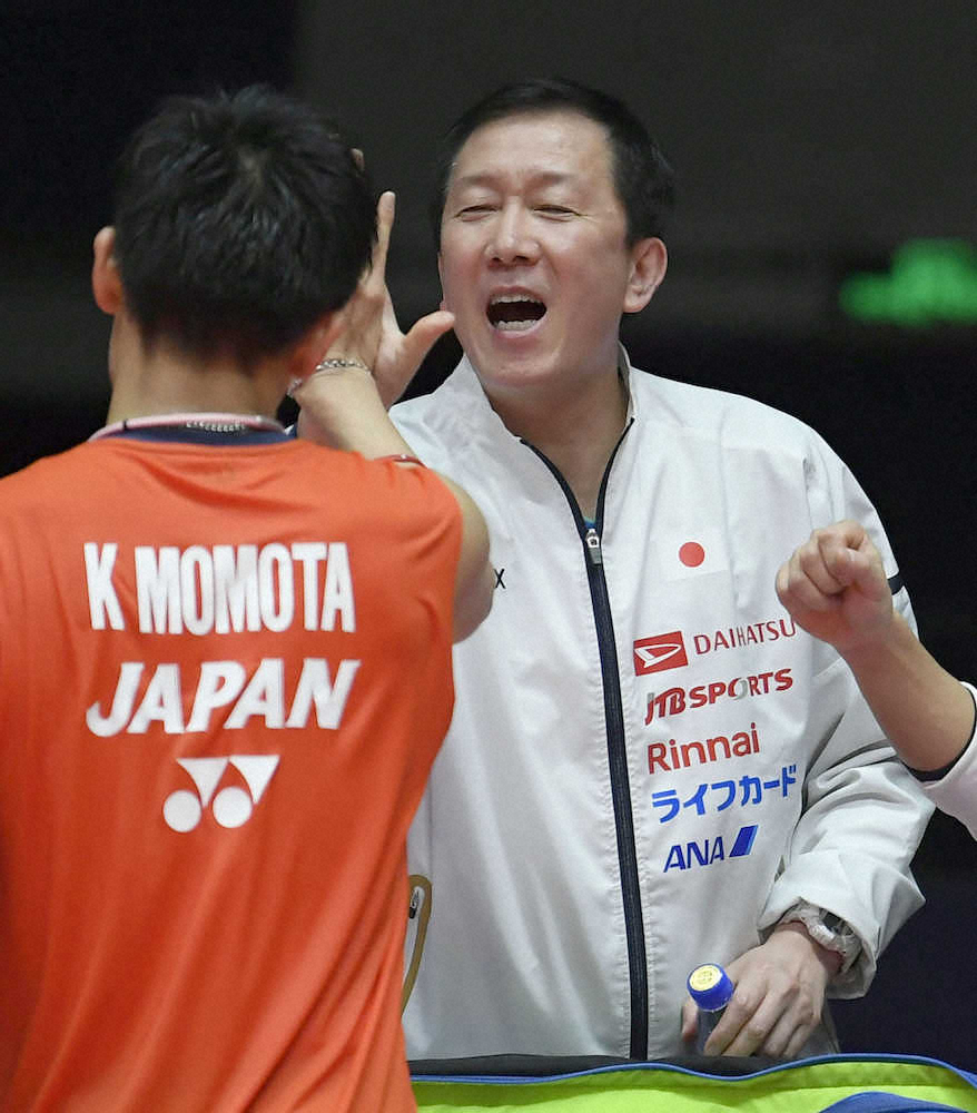 男子シングルスで優勝した桃田（手前）とタッチを交わす日本代表の朴柱奉ヘッドコーチ