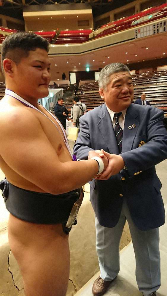 昨年の全日本相撲選手権で優勝した谷岡（左）を祝福する近大・伊東監督