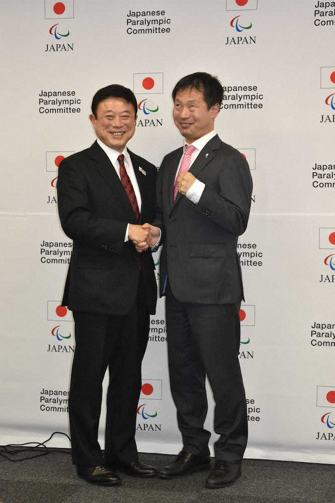握手を交わす日本パラリンピック委員会（JPC）副委員長の高橋秀文氏（左）と日本選手団団長の河合純一氏