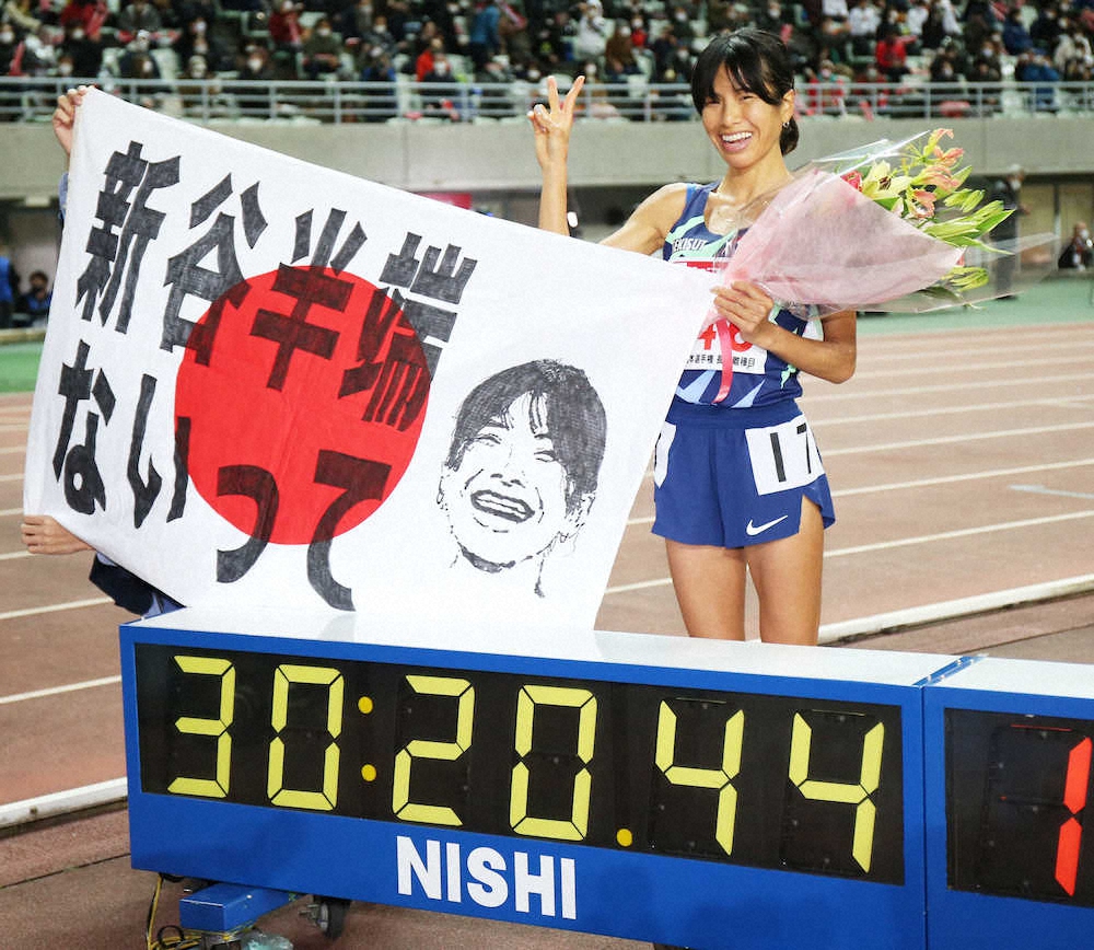 昨年12月の陸上日本選手権女子10000メートルで日本新記録で東京五輪出場を内定させ、応援団お手製の日の丸を手に笑顔の新谷仁美（撮影・北條　貴史）