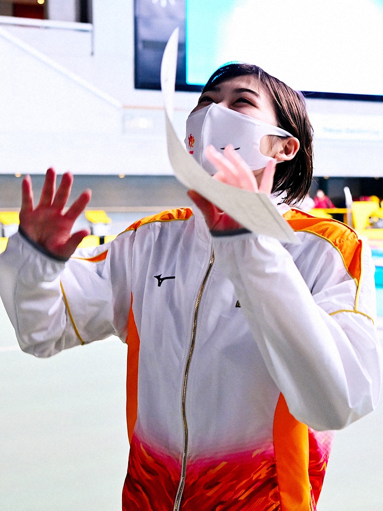 女子50メートルバタフライで日本学生新記録を樹立し、表彰状を手にスタンドに手をふる池江璃花子