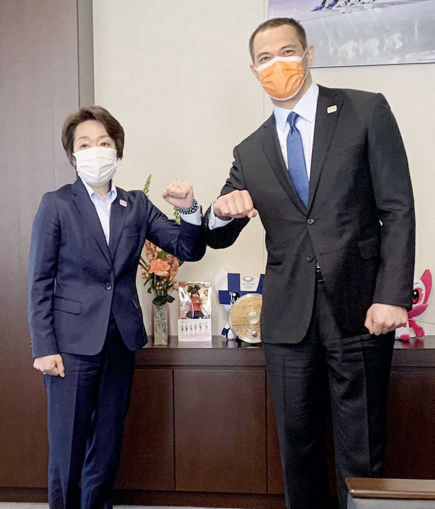 スポーツ庁を訪問し、室伏長官（右）と腕を合わせる東京五輪・パラリンピック組織委の橋本会長