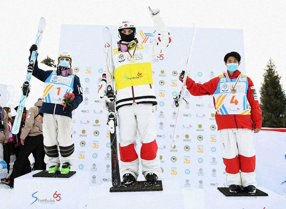 フリースタイルスキーの世界選手権デュアルモーグル男子で3位に入り表彰台に立つ堀島行真（右）（FIS提供・共同）